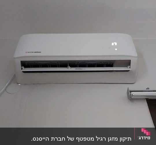 מזגן קיר לבן מותקן על קיר פנימי